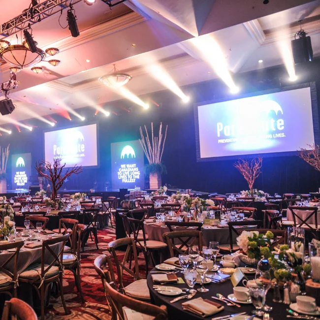 Dining tables in a large conference room with a stage